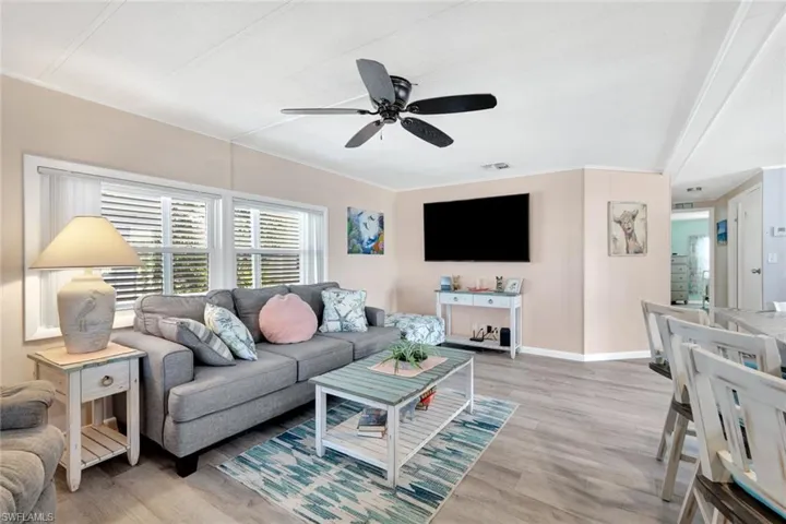 Comfortable living room with luxury vinyl flooring, recessed lighting, and large windows filling the home with natural light.