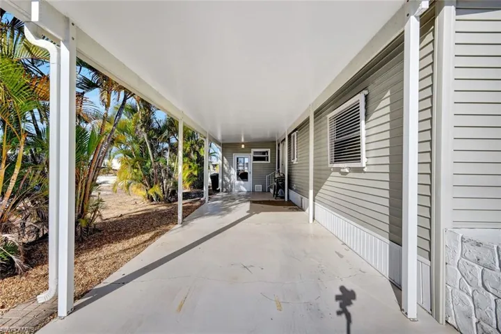 Covered  car port offering a welcoming entrance and additional outdoor living space.