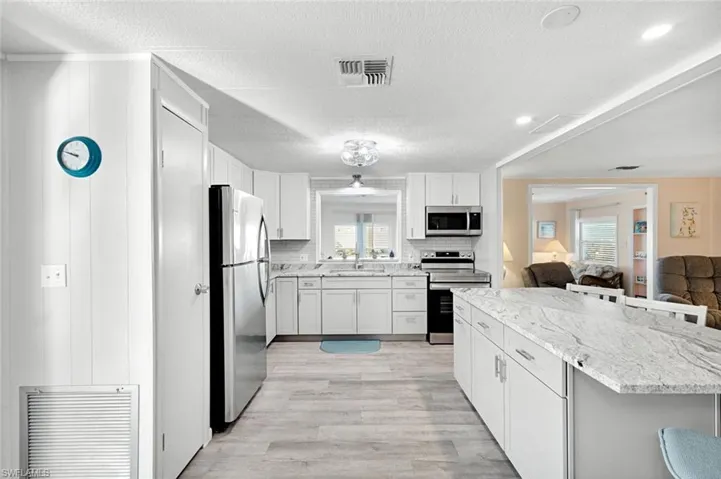Oversized kitchen island with quartz countertops offering additional seating, storage, and entertaining space.