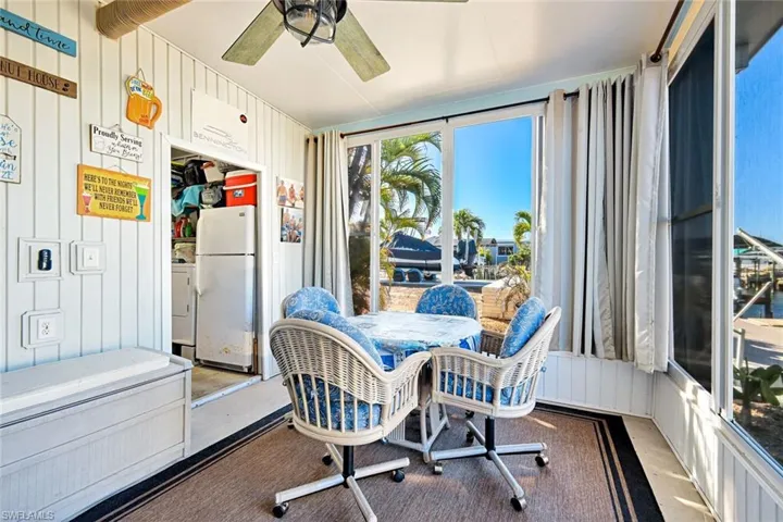 Bright Florida room overlooking the canal, ideal for morning coffee, reading, or enjoying waterfront views year-round.