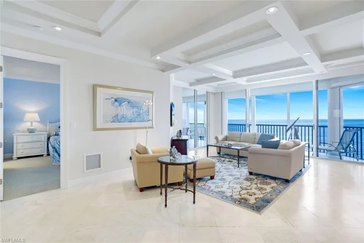 Living room with breath-taking 8th floor water views, beam ceilings, recessed lighting, and ornamental molding
