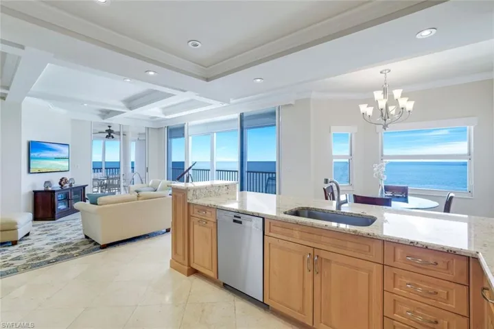 Kitchen with open floor plan, a chandelier, dishwasher, stainless steel sink, coffered ceilings