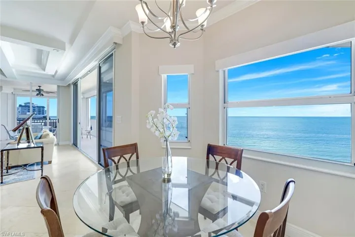 Dining space with ornamental molding, a chandelier, and a water view