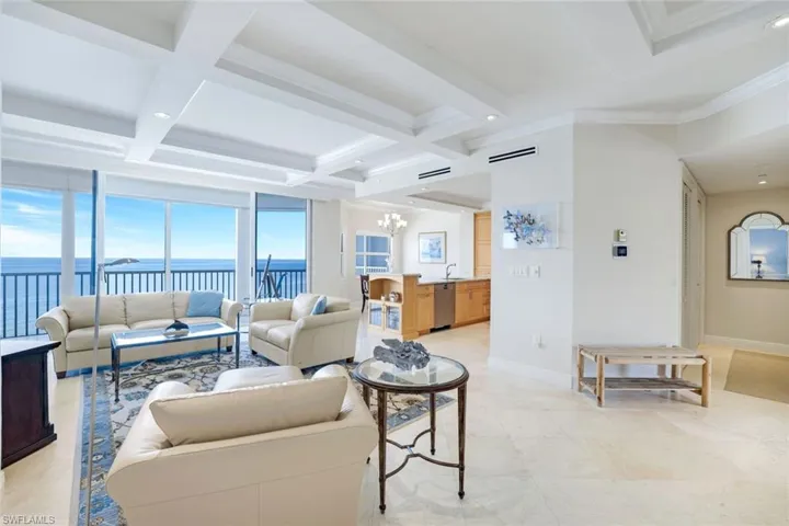 Living area with coffered ceilings, amazing water views, a chandelier, beam ceiling, recessed lighting and linear vents.
