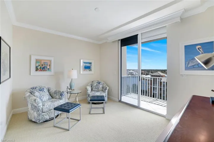 Carpeted living area featuring crown molding and baseboards