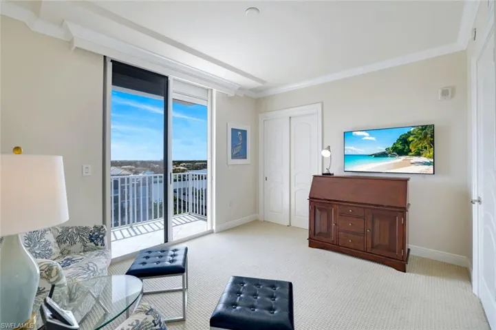 Third bedroom or den featuring light carpet, ornamental molding, electronic window coverings and hurricane shutters.