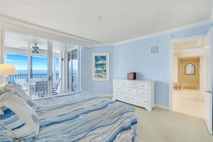 Master bedroom with sliders to lanai, light carpet, and crown molding.