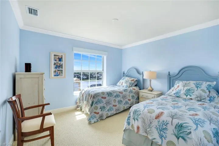 Carpeted second bedroom featuring ornamental molding and baseboards.  Draw string window coverings.