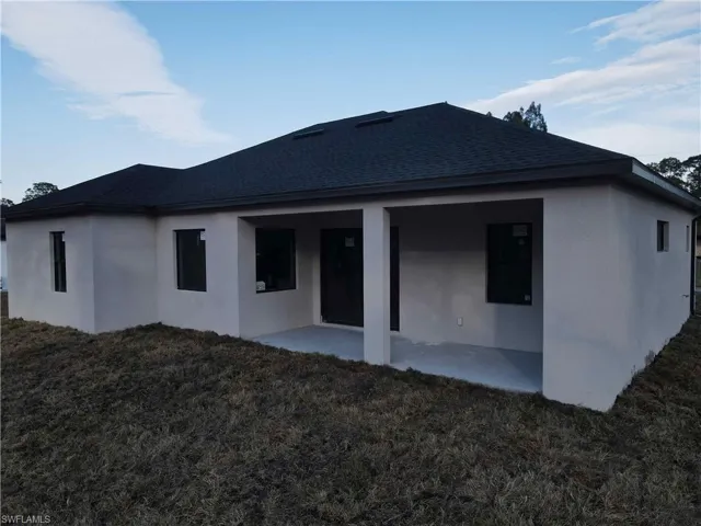 Rear view of property with a yard and a patio area