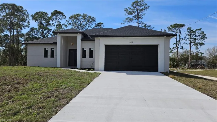 View of front of home featuring a garage and a front yard
