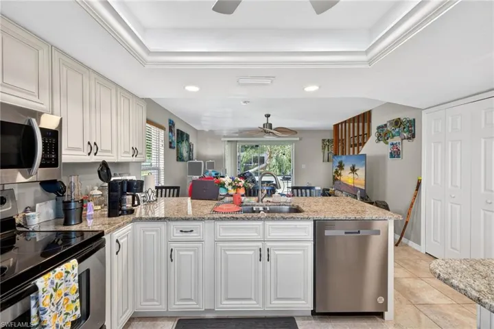 Kitchen featuring light-toned cabinetry, granite countertops, and stainless steel appliances