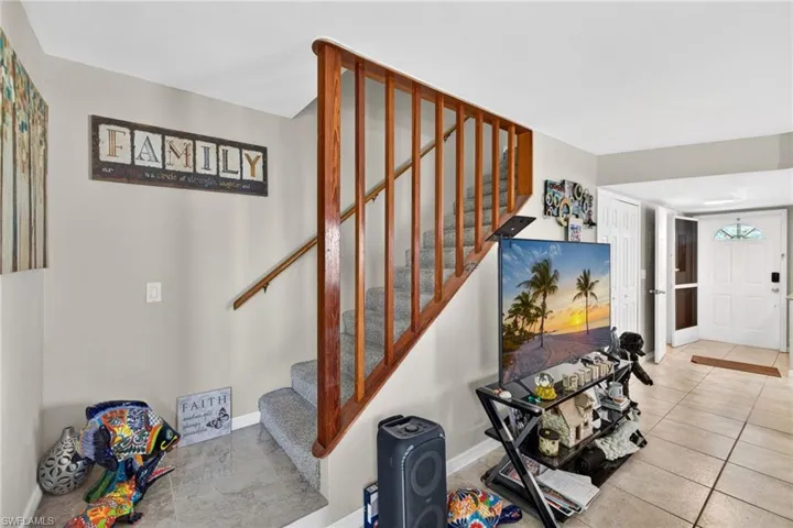 Staircase with wood balusters and carpeted treads, featuring a wood handrail