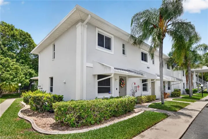 Two-story residence featuring white stucco exterior, white trim, and a white roofline