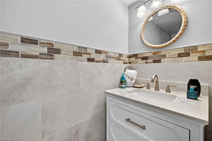 Vanity featuring a built-in sink, stone countertop, and brushed nickel faucet