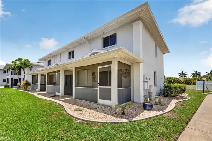 Contemporary multi-story exterior with multiple screened-in porches, stucco siding, and a gabled roofline