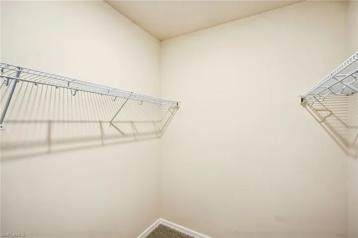 Walk in closet with carpet floors