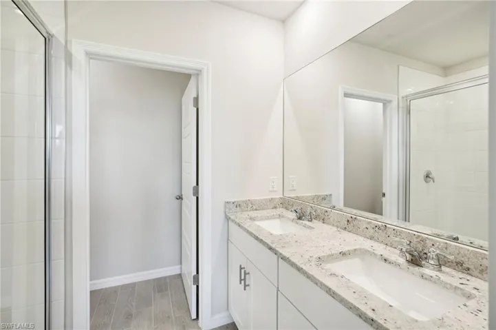 Bathroom featuring walk in shower, hardwood / wood-style flooring, and vanity