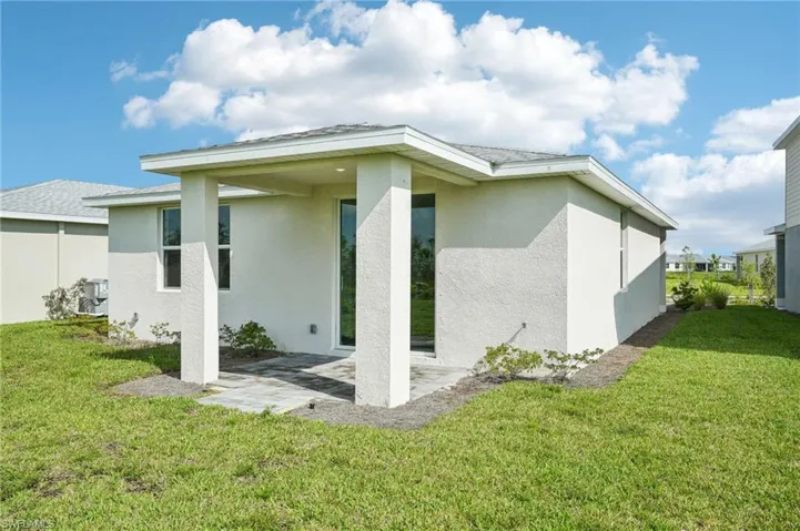 Back of property with a lawn and a patio area