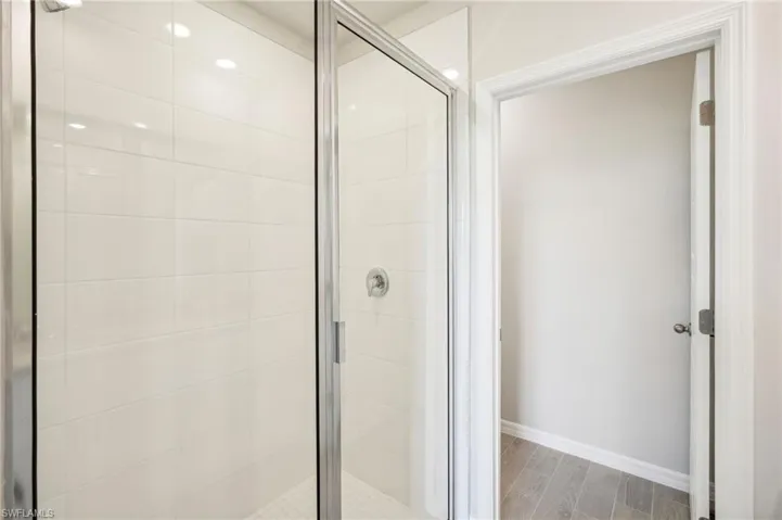 Bathroom with walk in shower and hardwood / wood-style flooring