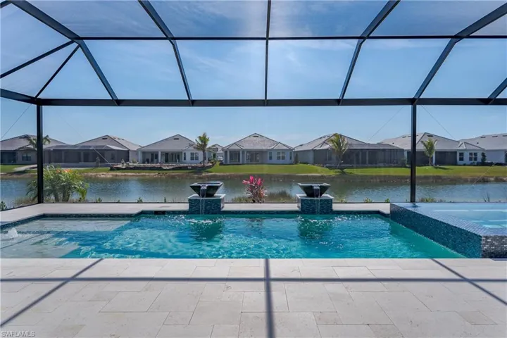 View of pool featuring a residential view, glass enclosure, and a water view