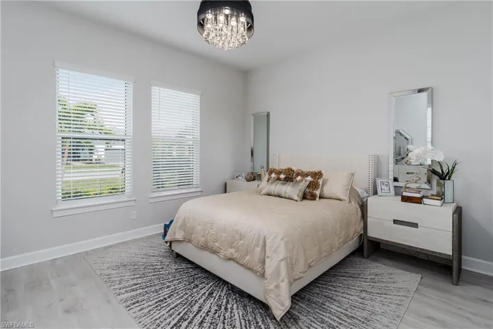 Bedroom with wood finished floors and a chandelier