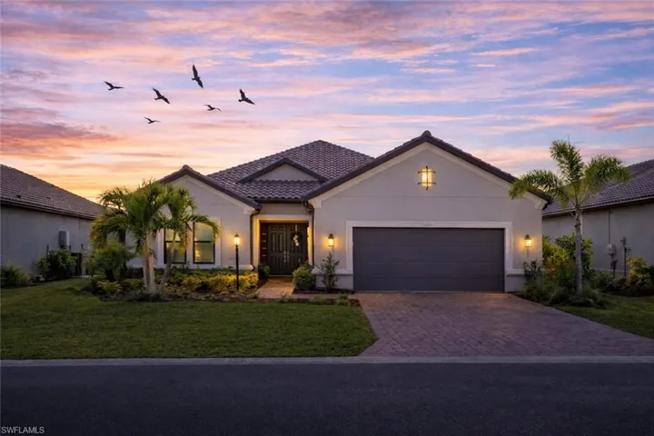 Mediterranean / spanish house with decorative driveway, a front yard, a garage, and stucco siding