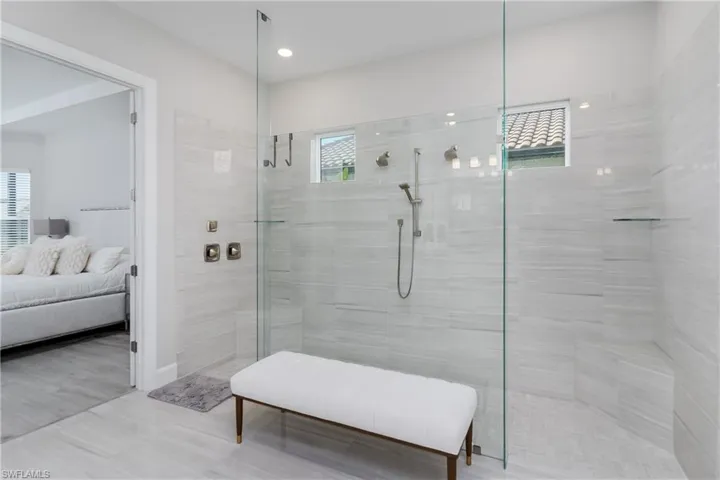 Bathroom featuring a walk in shower, connected bathroom, and recessed lighting