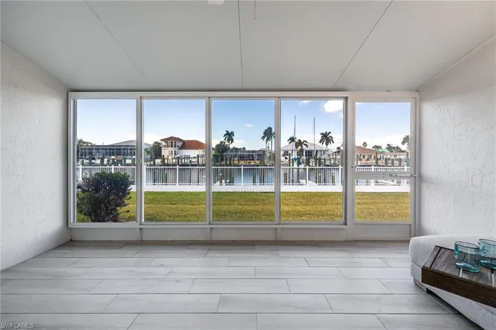 Sunroom / Lanai  with a textured wall and a water view
