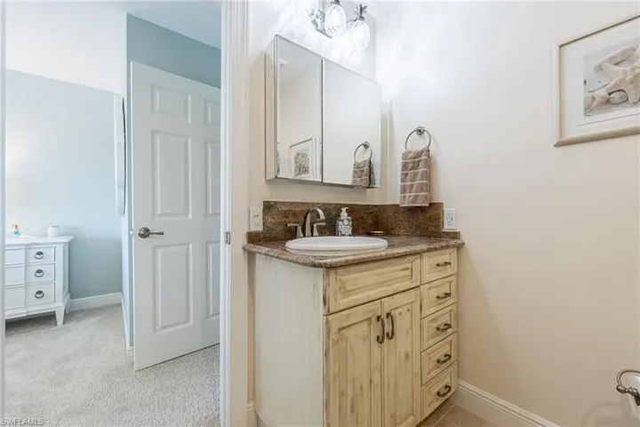Bathroom featuring vanity and backsplash