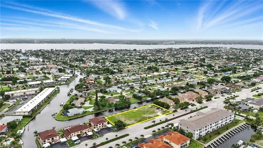 Aerial view of residential area featuring property parcel outlined and a large body of water