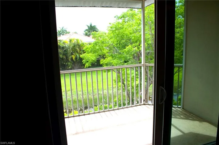 Balcony featuring a metal railing, concrete flooring, and sliding glass doors