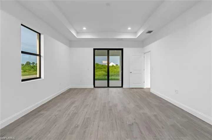 Unfurnished room with a raised ceiling and hardwood / wood-style floors