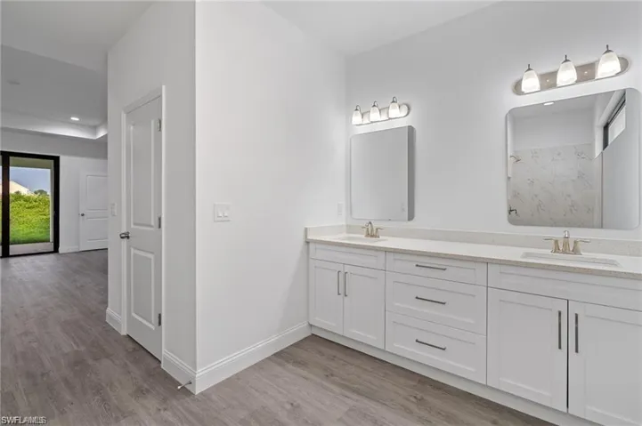 Bathroom with double vanity and hardwood / wood-style flooring