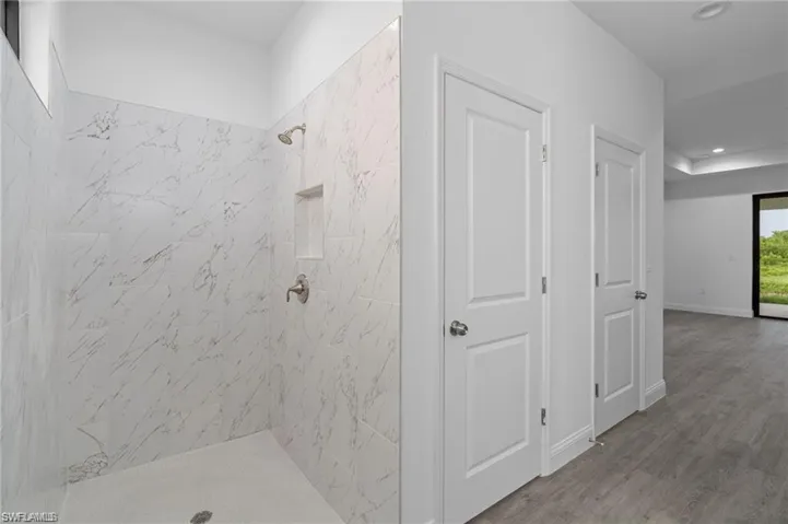 Bathroom featuring hardwood / wood-style floors and a tile shower