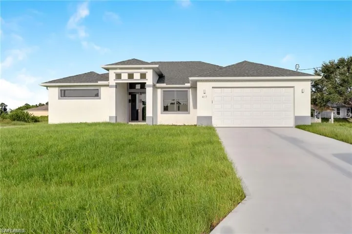 Prairie-style house featuring a garage and a front yard