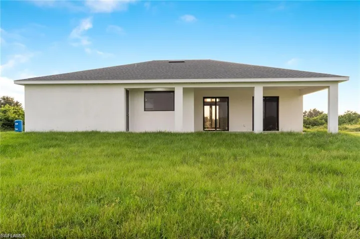 Back of house with a yard