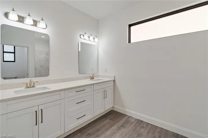 Bathroom featuring dual vanity and hardwood / wood-style floors