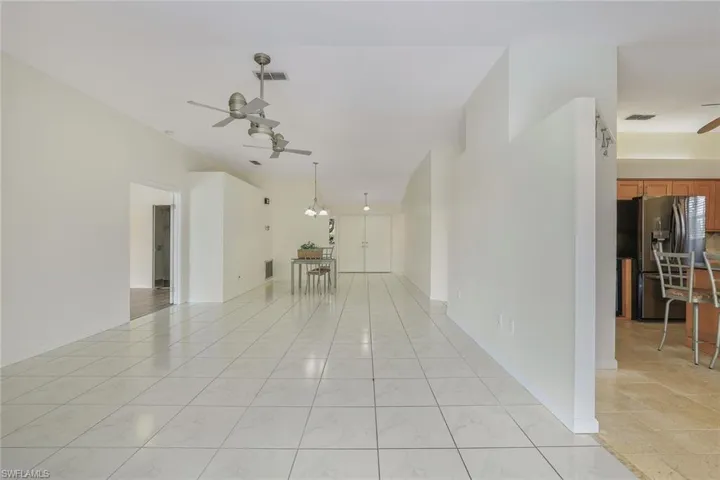Living room featuring ceiling fan with chandelier