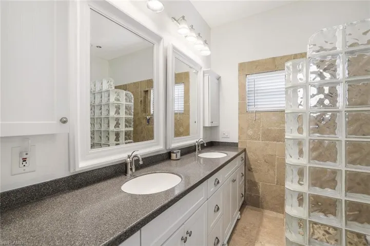 Bathroom featuring vanity, a shower, and tile flooring
