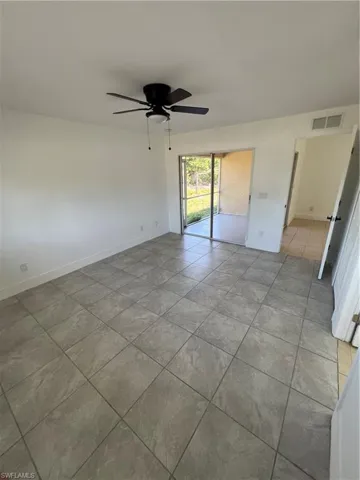 Spare room featuring a ceiling fan, baseboards, and light tile patterned flooring