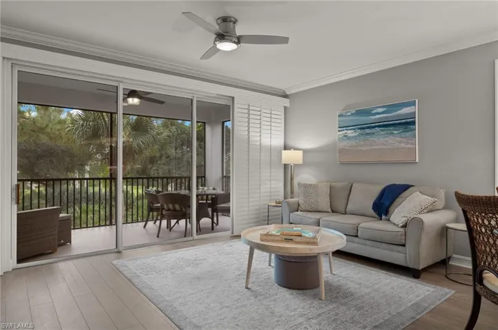 Living room with sliders to the lanai, ceiling fan and luxury vinyl plank floors.