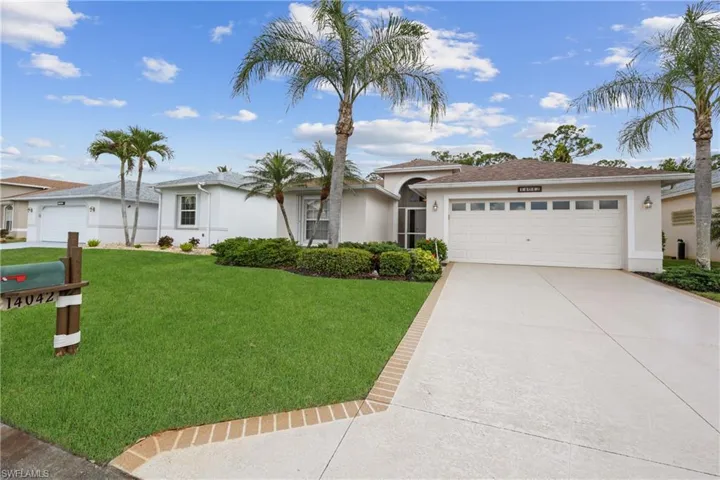 Ranch-style home featuring stucco siding, a front yard, driveway, and a garage