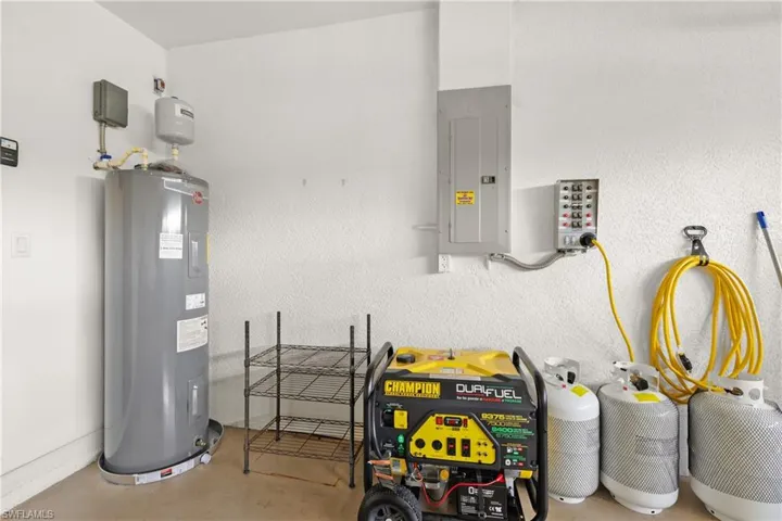 Garage featuring generator and whole-home plug-in, electric water heater, and electric panel