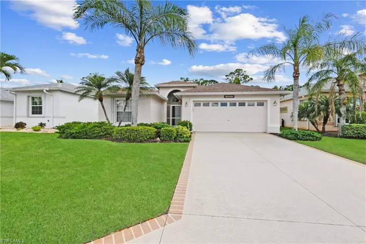 View of front of home featuring a front landscaped yard, stucco siding, a garage, and concrete driveway