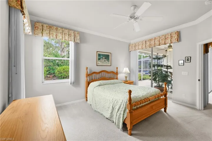 Bedroom featuring light colored carpet, multiple windows, and crown molding