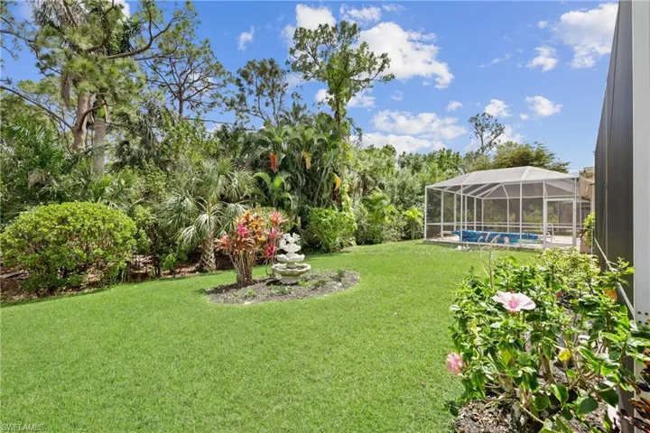 View of yard featuring glass enclosure and an outdoor pool