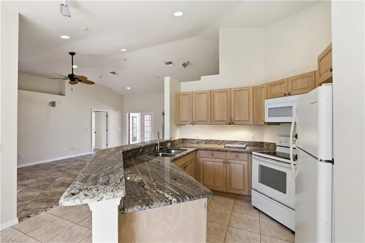Granite kitchen with all appliances including dishwasher to the left of the sink