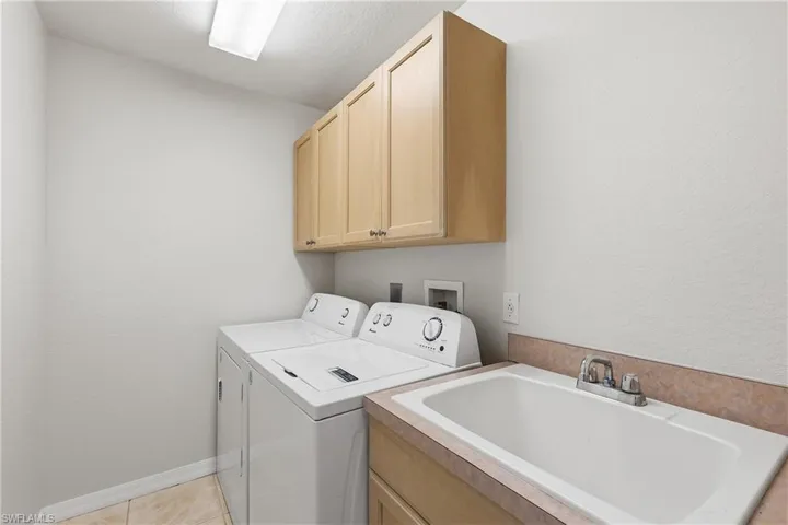 In residence laundry with sink and cabinets