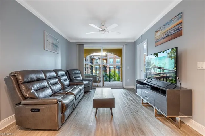 Living area featuring crown molding, light wood-type flooring, and ceiling fan