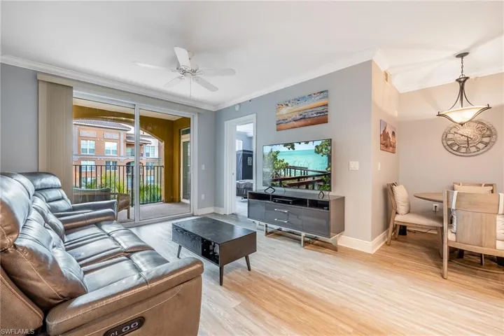 Living room featuring wood finished floors, ornamental molding, and ceiling fan